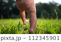 baby takes first steps in the park. happy family kid dream concept. dad teaches his son to walk takes the first steps in the park on green grass. baby son taking first lifestyle steps 112345901