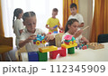 child group playing fishing. children in kindergarten play with toys. happy family kid lifestyle dream concept. a group of children collect building blocks in a kindergarten indoors 112345909