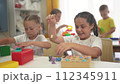 child group playing fishing. children in kindergarten play with toys. happy family kid dream concept. a group of children collect building blocks in a lifestyle kindergarten indoors 112345911