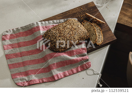 Sliced bread on wooden board in linen bag. Kitchen aesthetic concept 112539521