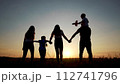 family walks across the field. happy childhood concept for little child. big happy family walks across the field on the grass holding hands, sunset on the background, silhouettes lifestyle 112741796