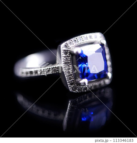 Blue, silver and ring on a black background for luxury, expensive and present for engagement or marriage in studio. Jewelry, diamonds and crystal rock in closeup with shine and reflection for a gift 113346183