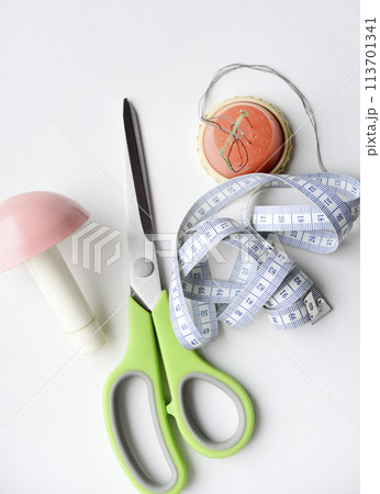 Sewing scissors, measuring tape and thread with a needle. Sewing kit. 113701341