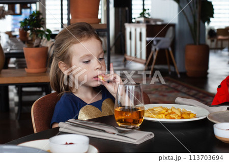 Little girl enjoying dinner at the restaurant 113703694