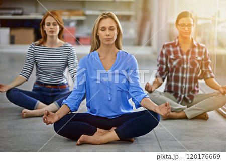 Refreshing their minds before work. Full length shot of three businesswomen meditating in the office. 120176669