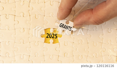 Planning 2025 grants new year symbol. Concept words 2025 Grants on beautiful white puzzle. Beautiful white puzzle background. Businessman hand. Business 2025 grants new year concept. Copy space. 120116116