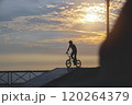 Silhouette unrecognizable Young man doing ramp jump stunt on bmx bicycle on sunset. 120264379