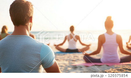 Group yoga practice on the beach at sunset for relaxation and mindfulness 120375854