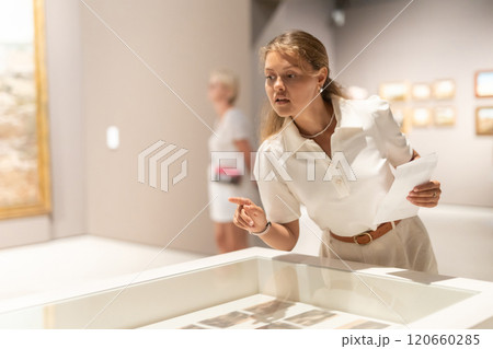 Girl looks at various paintings and drawings at an art exhibition in museum 120660285