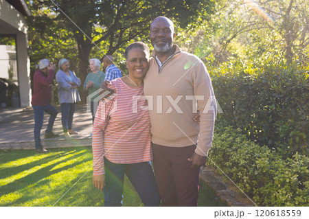 Happy african american couple of senior friends embracing and smiling in sunny garden 120618559