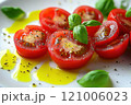 Freshly sliced tomatoes drizzled with olive oil and garnished with basil, creating vibrant and appetizing dish. Perfect for salads or as side 121006023