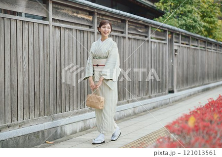 古民家の横を歩く着物の女性 121013561