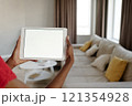 Medium close up of unrecognizable female hands holding white rectangular tablet with total white screen 121354928