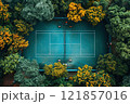 Aerial view of a secluded tennis court surrounded by vibrant greenery and autumn trees 121857016