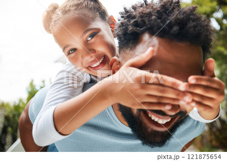 Happy, playful and carefree dad and daughter playing outdoors in the park and child covering fathers eyes. Portrait of an excited, joyful and cheerful child having fun with her parent in nature 121875654