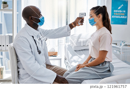 Temperature, thermometer and covid routine with doctor, medical professional and healthcare worker in clinic, hospital or wellness center. Woman or patient with mask checking fever to prevent disease 121961757