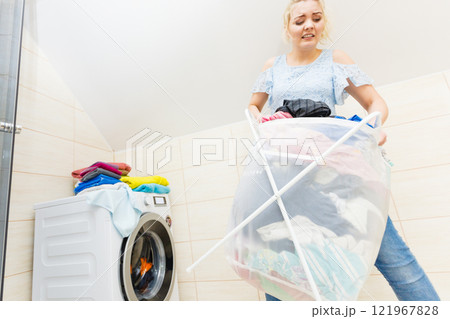 Woman carry big basket of dirty clothes laundry. 121967828