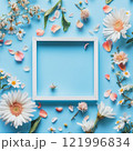 Colorful floral arrangement with empty frame on blue background during a bright day 121996834