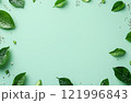 Green leaves and delicate flowers arranged on a mint background for a refreshing natural design 121996843