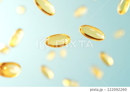 Fish oil capsules floating on a light blue background 122092260