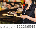 Happy woman holding coffee cup and mini cake at cafeteria. 122236545