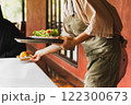 Waitress serving green vegetable salad with bread bun in the morning. 122300673