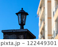 Small lamp lamp on a stone pillar. In the background a tree and blue sea. High quality photo. 122449301