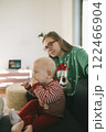 A warm and cozy family moment shared between a joyful child and an adult wearing a festive sweater 122466904