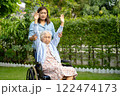 Caregiver help and care Asian senior woman patient sitting on wheelchair and exercise in park at hospital. 122474173