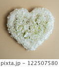 Heart made of white lilac flowers on pastel beige background. Still life romantic composition of Valentines day holiday copy space for your text invitation greeting card 122507580