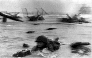 A blurry picture of an American GI belly crawling through the surf