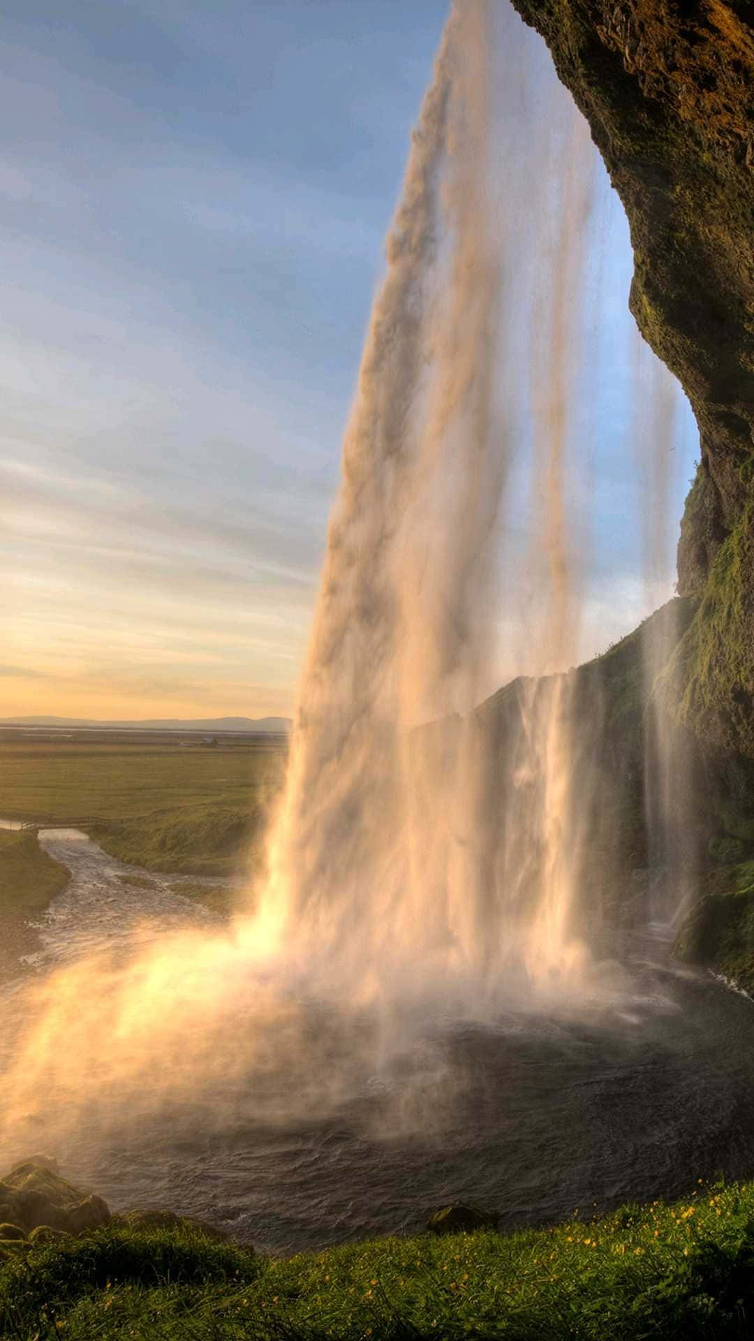 A stunning view of an iPhone by a beautiful waterfall. Wallpaper