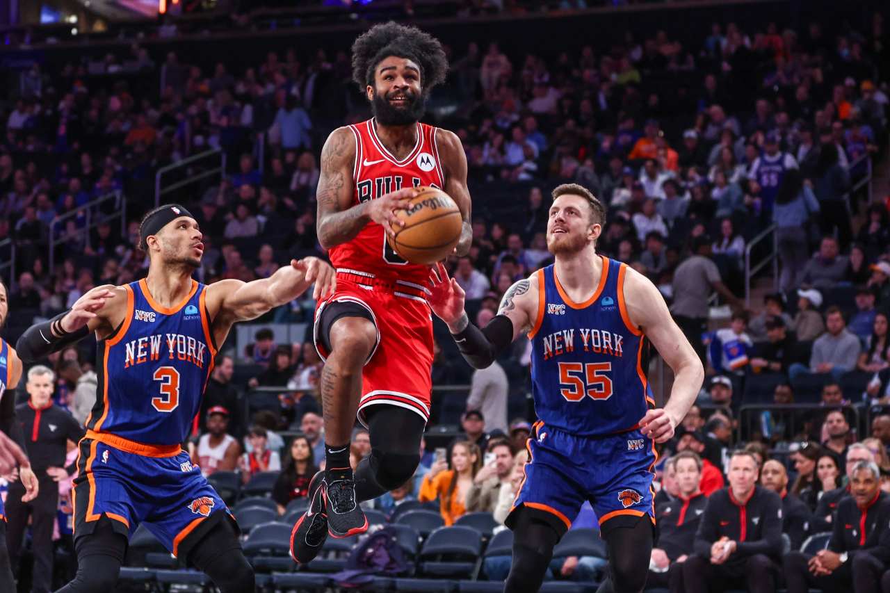 Chicago Bulls guard Coby White (0) drives past New York Knicks guard Josh Hart (3) and center Isaiah Hartenstein (55) in the third quarter at Madison Square Garden.