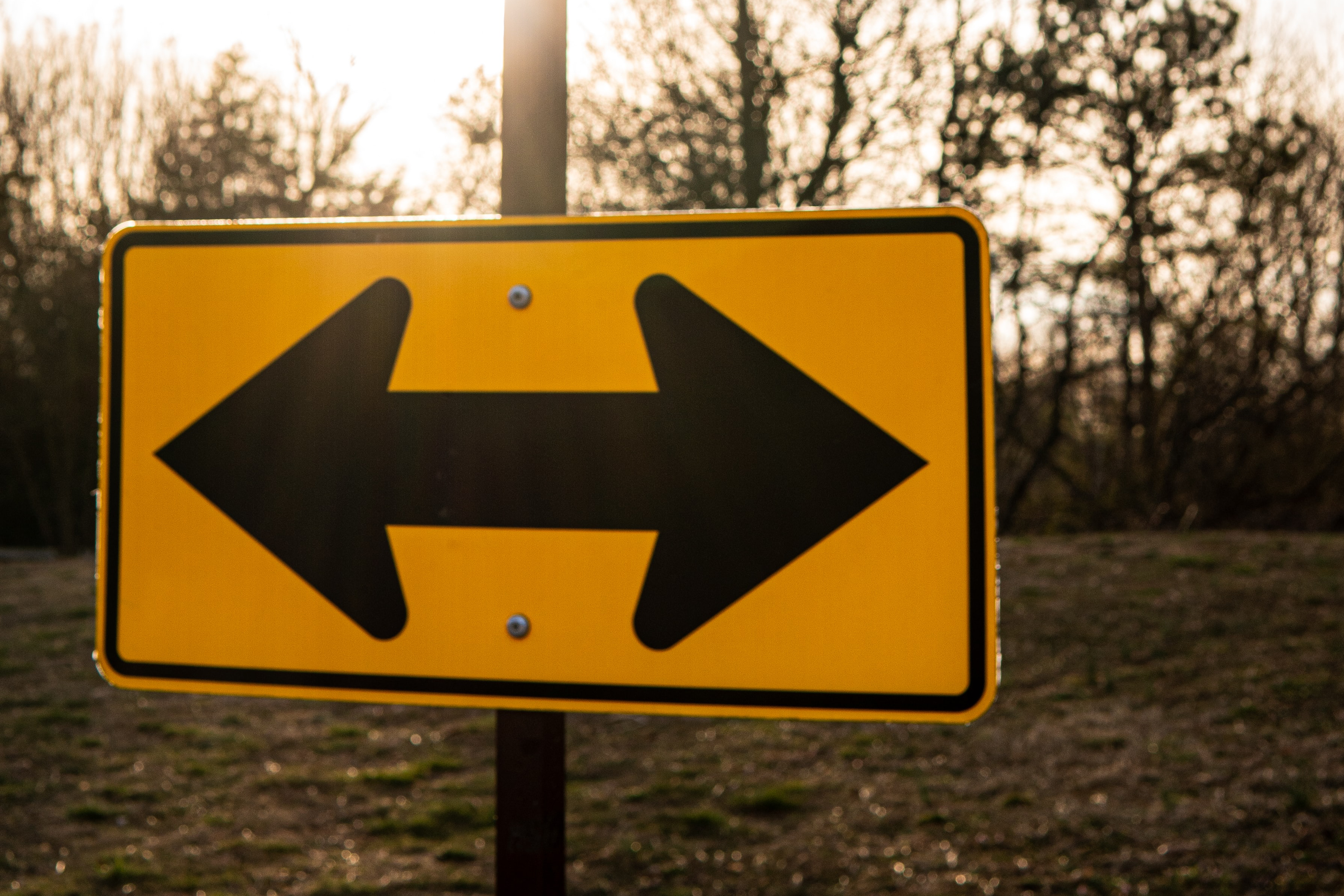 Photo of a road sign pointing left and right.