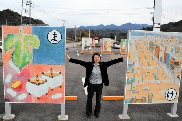 「県都前橋　生糸の市」（右）「繭と生糸は日本一」（左）の間に立つ島津和実さん=2024年12月13日午後3時2分、群馬県東吾妻町、高木智子撮影