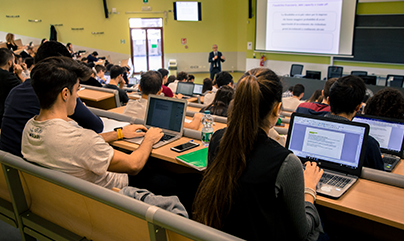 Studenti e studentesse in aula che seguono una lezione