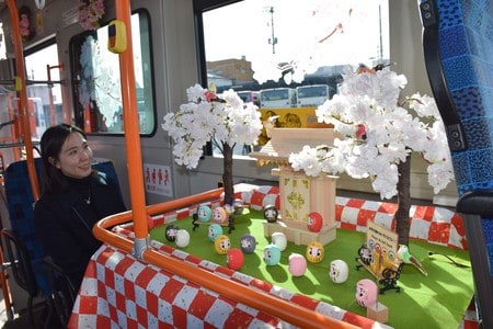 桜やだるまを展示しているバス車内＝１３日、岡山市北区