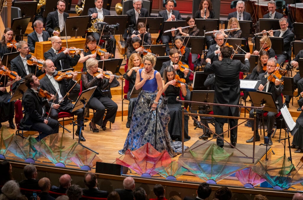 Soprano singer singing in front of orchestra