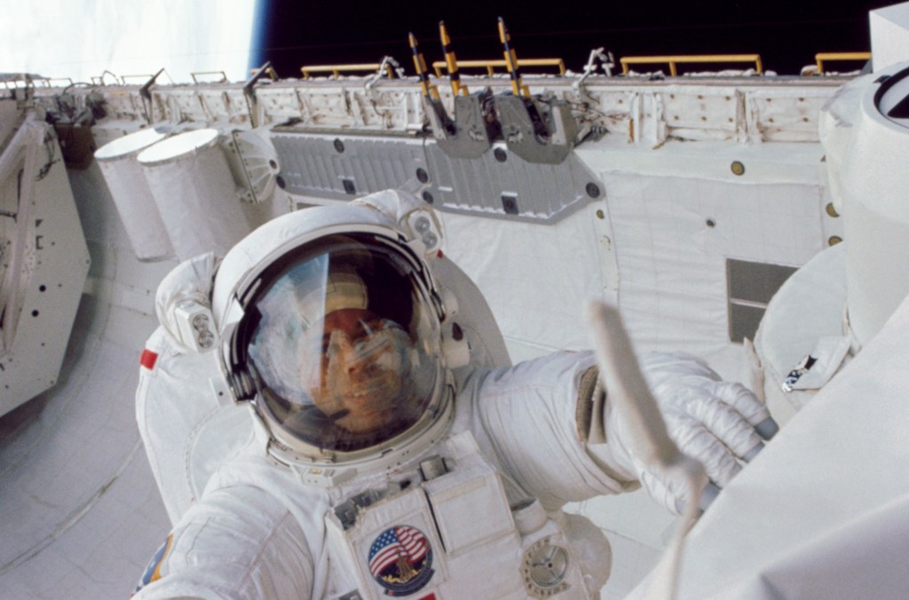 Astronaut David C. Leestma during an extravehicular activity (EVA) in the Challenger's aft cargo hold. He appears to be working on the orbital refueling system (ORS). Behind him can be seen the Get Away Special canisters and part of a cradle for satellites.