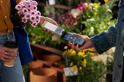 Two people using Apple's Tap to Pay feature on iPhones for a contactless transaction.