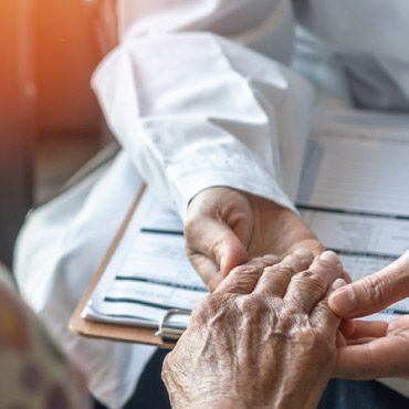 Health care worker holding patient's hand