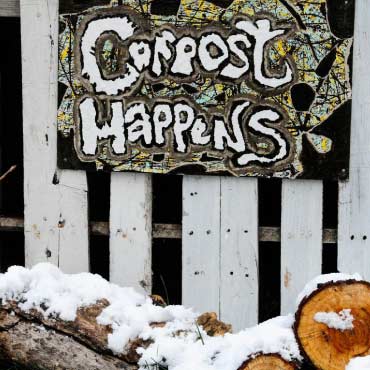 Fence with "compost happens" sign