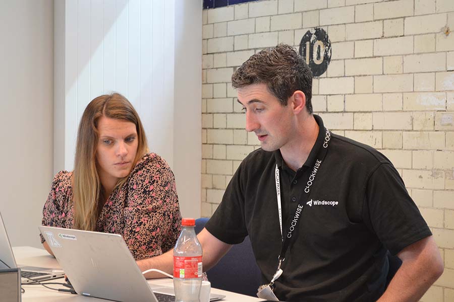 Woman and man sat at a table looking seriously at a laptop