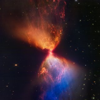 A proto-star spews out gorgeous plumes of gas in opposite directions in an hourglass shape, coloured in orange and blue hues against the black backdrop of space where distant galaxies can be seen like stars.