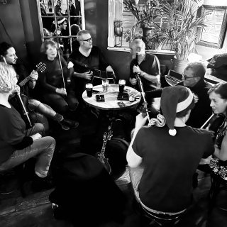 A circle of musicians around a table chatting .