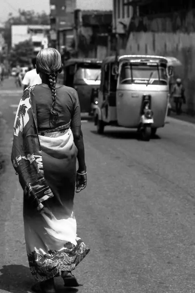 Three wheelers passing by woman with saree