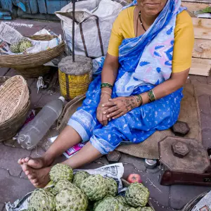 Woman selling both sugar apples and apples