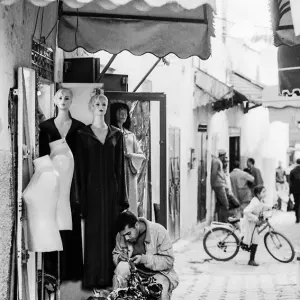 Fashioner working beside mannequins