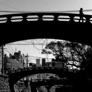 silhouette walking on bridge