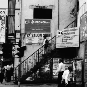 Woman with a saree descending stairway in front of advertisement